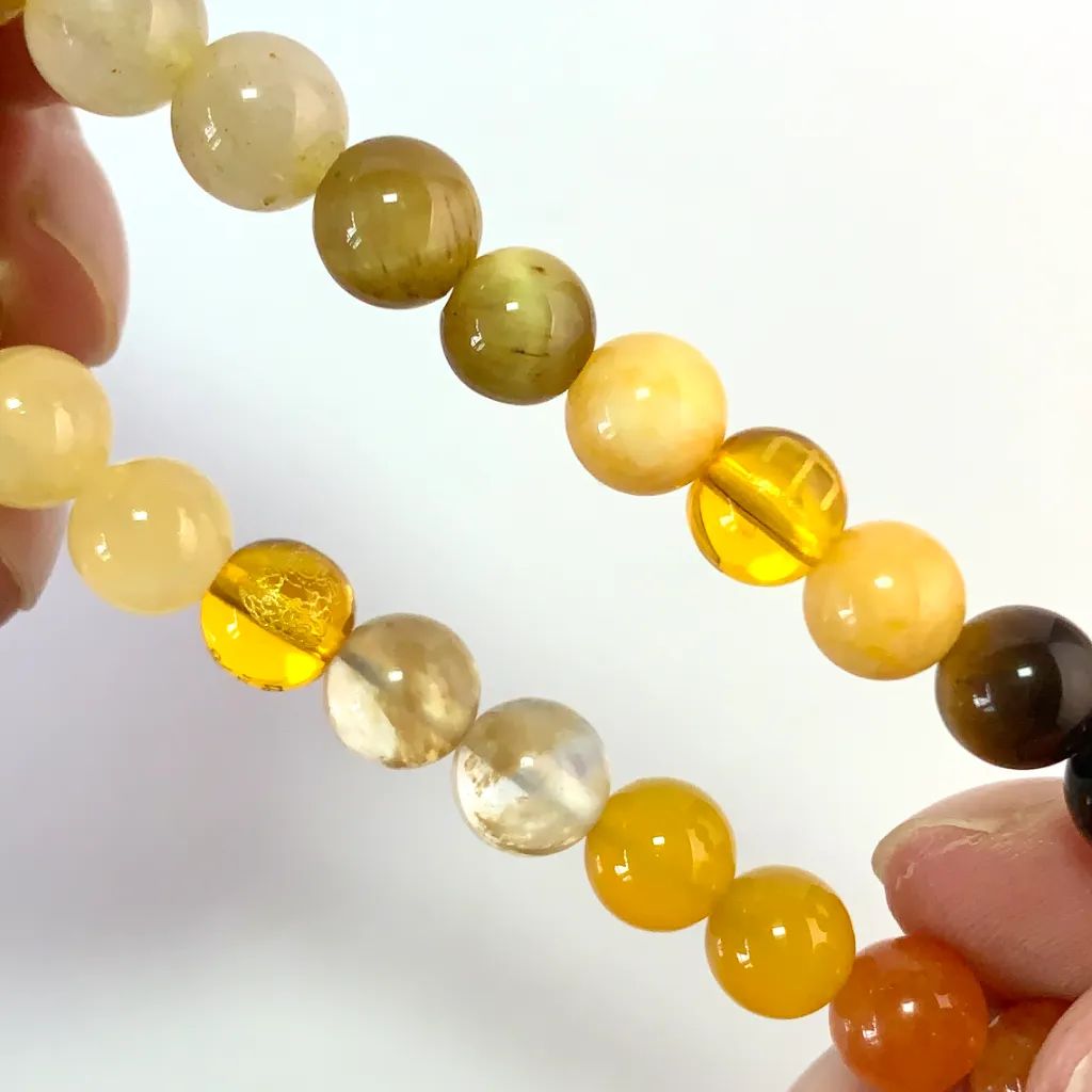 Detail of the Earth Element Bracelet: faceted yellow tower crystal, gold tiger eye band, and golden rutilated quartz catching the light